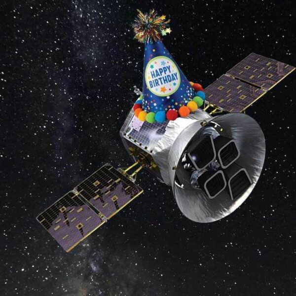 An illustration of the TESS spacecraft against a starry background with a pointed birthday hat perched on top of the spacecraft.